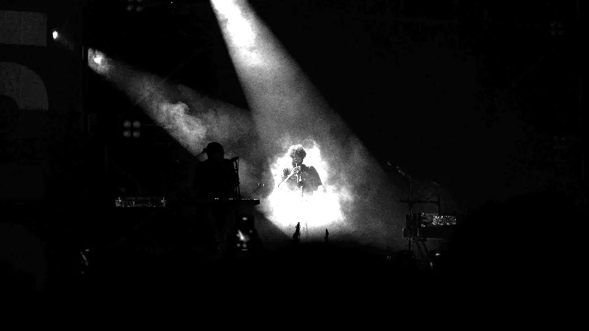 Stage lights over a darkened venue.