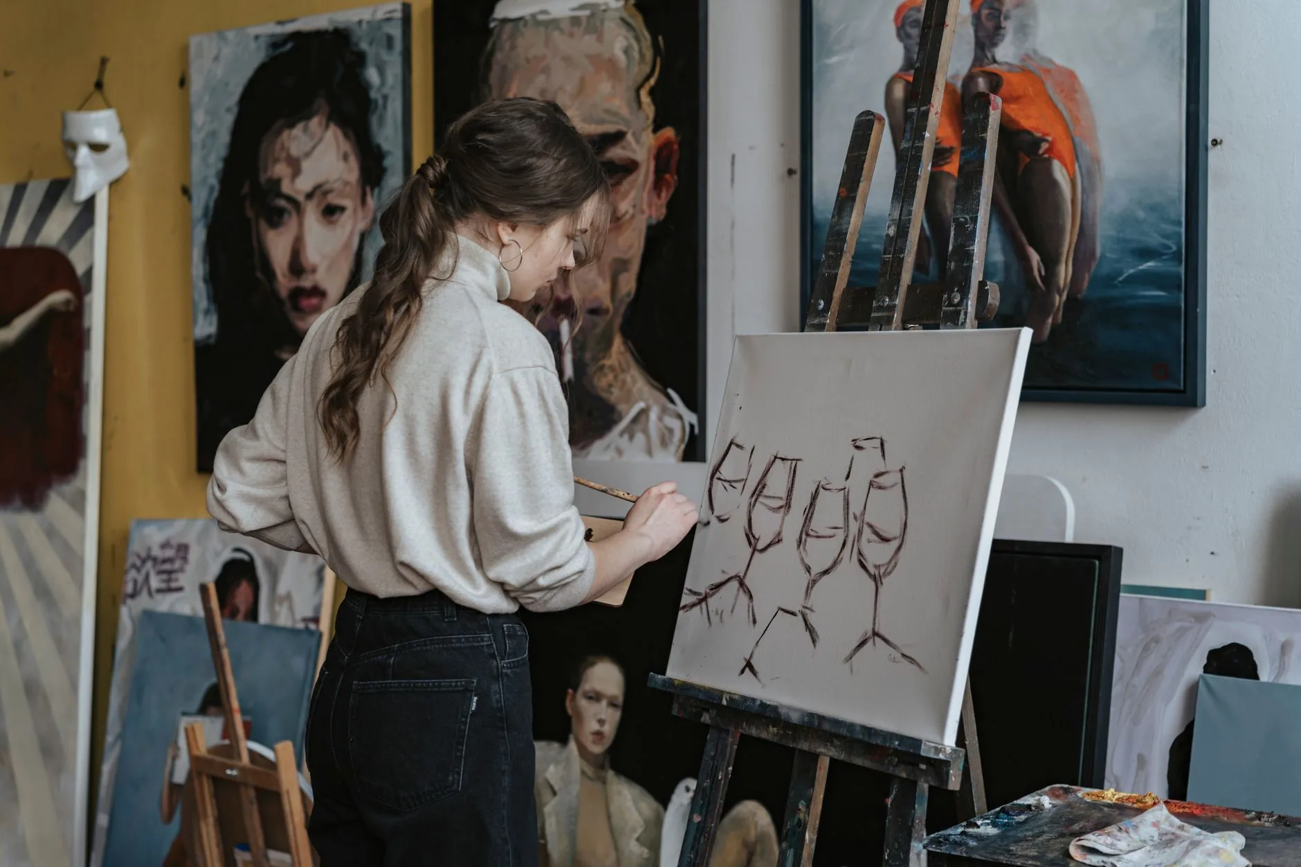 Art studio with muted light, showcasing shedskin visual art examples on walls.